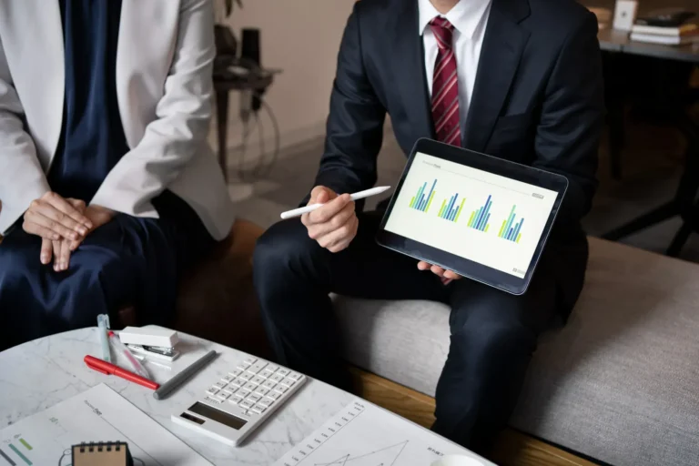 Profissional jurídico apresenta gráficos de desempenho em tablet, representando uso de dados e jurimetria.
